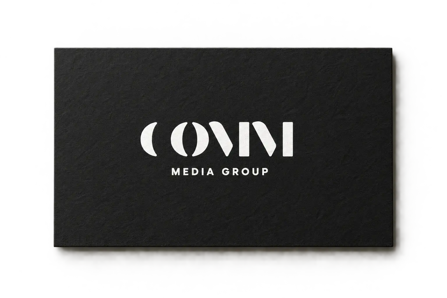 Tarjeta de visita negra de COMM Media Group con el logotipo en blanco.