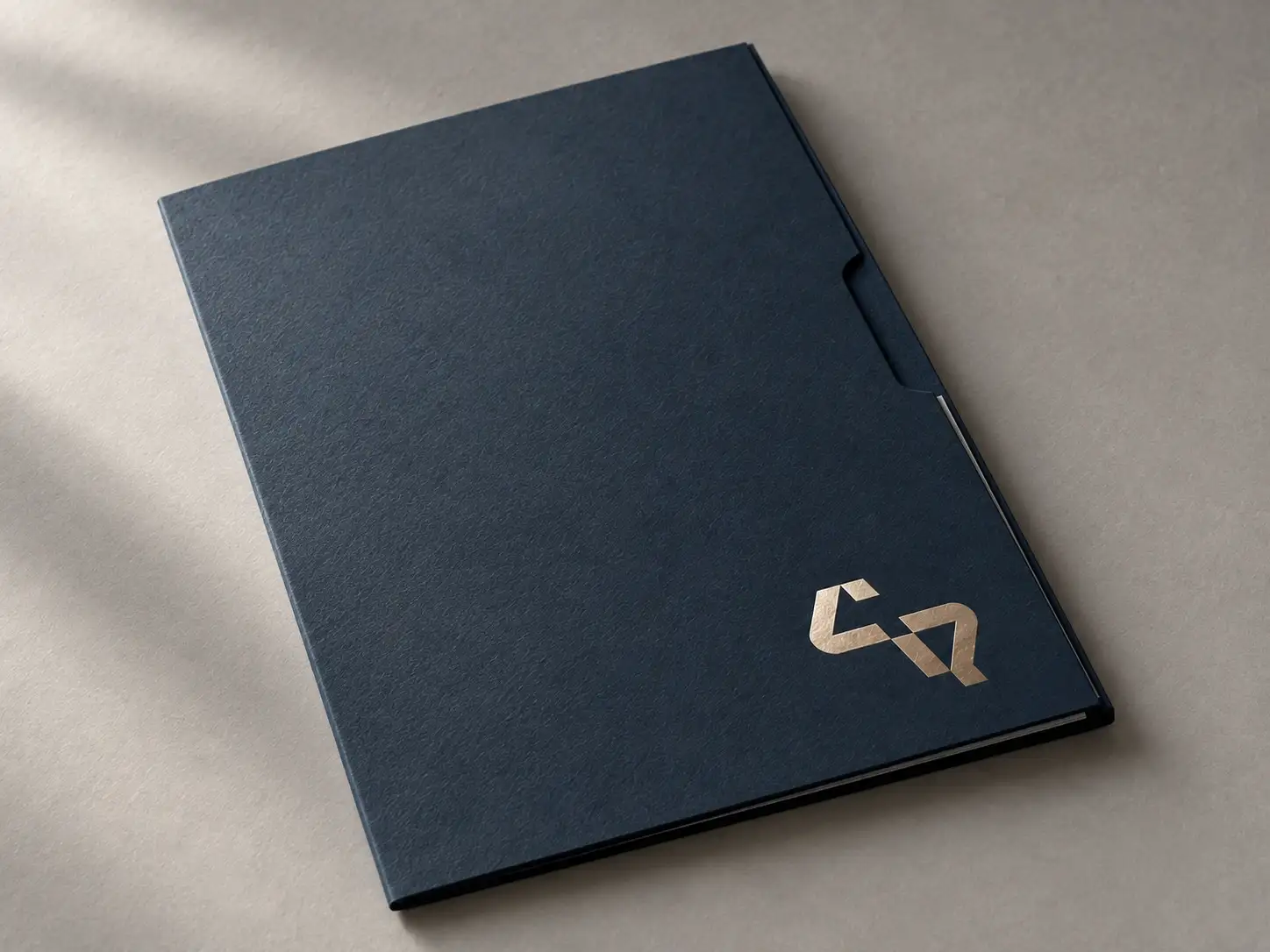 Carpeta azul noche con el símbolo de Renovando Caminos estampado en oro.